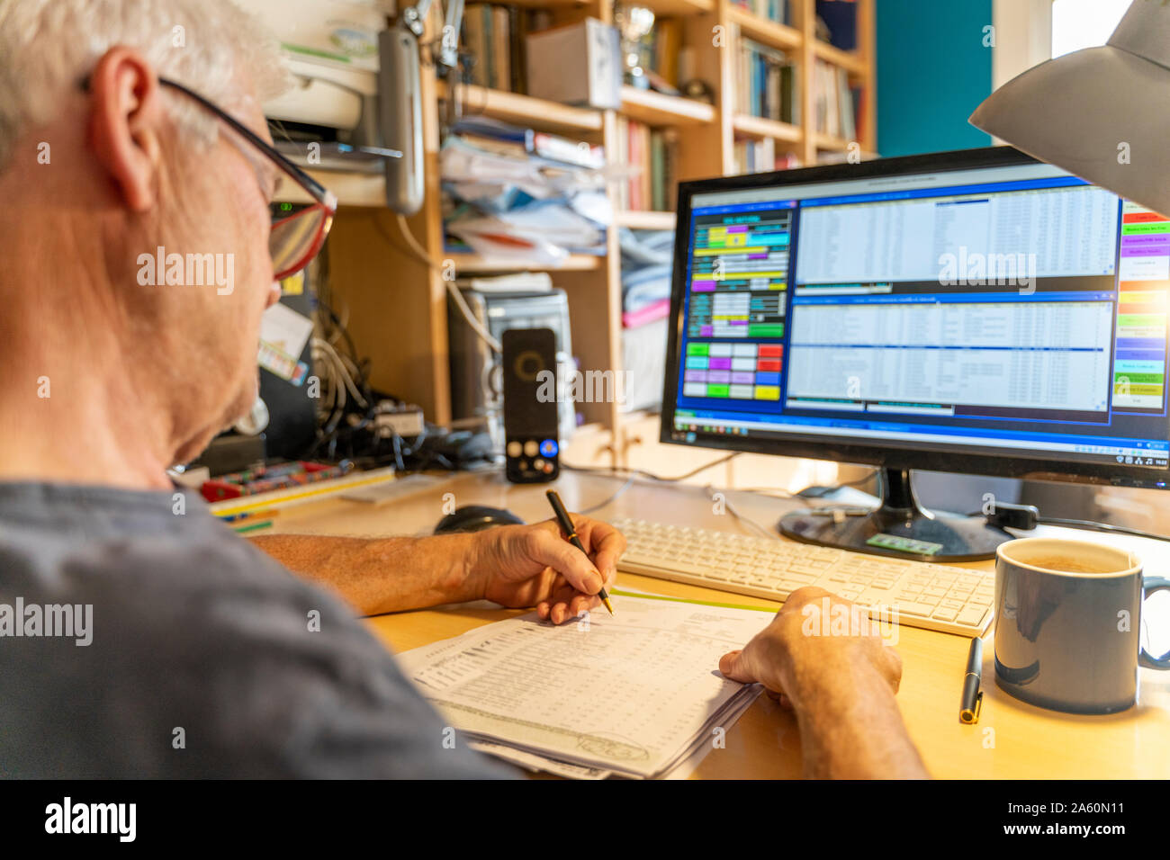 Älterer Mann bei der Arbeit im Büro mit Computer Stockfoto