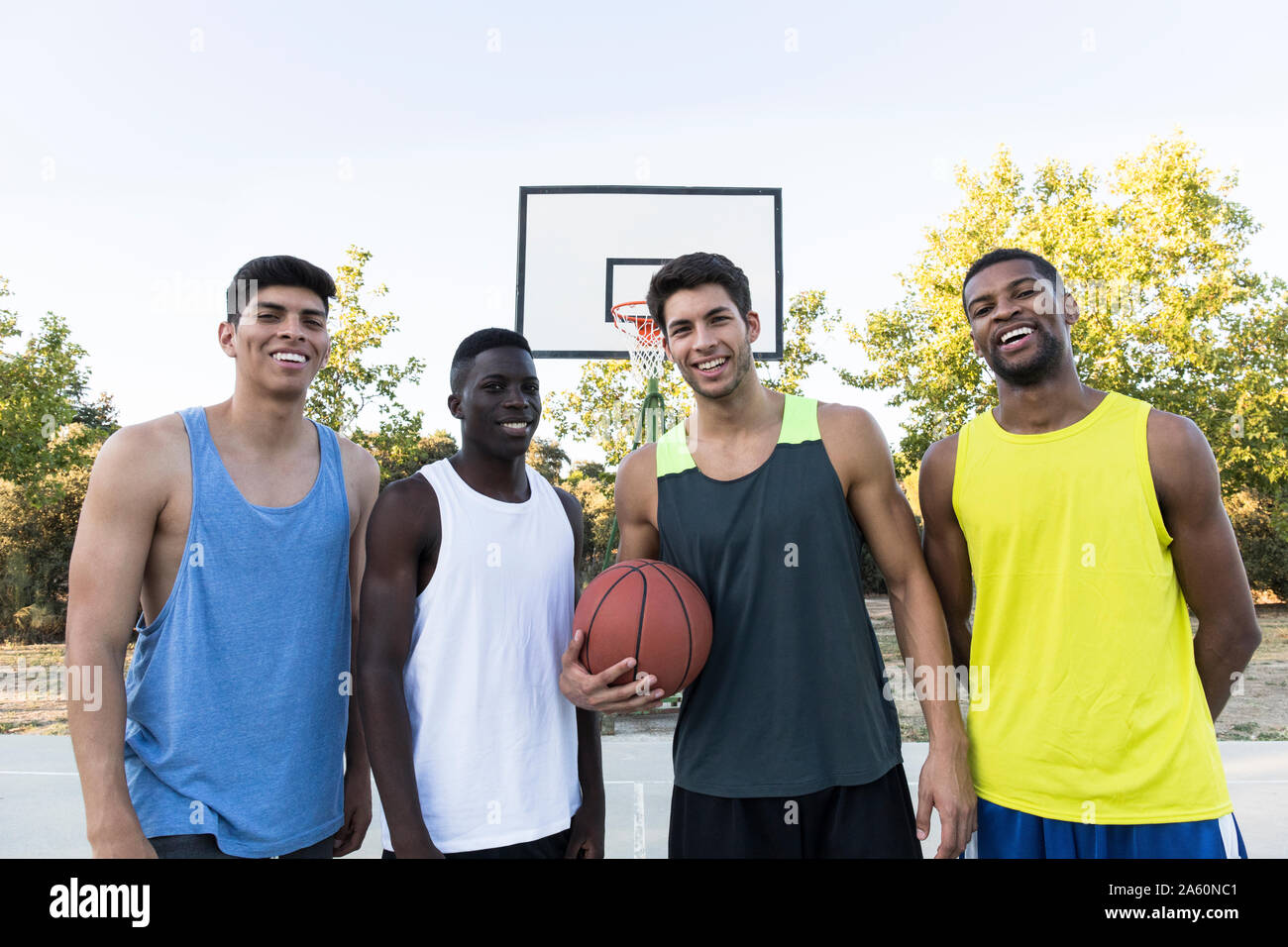 Gruppe der multirassischen Männer in Sportswear mit Kugel am Sportplatz Stockfoto