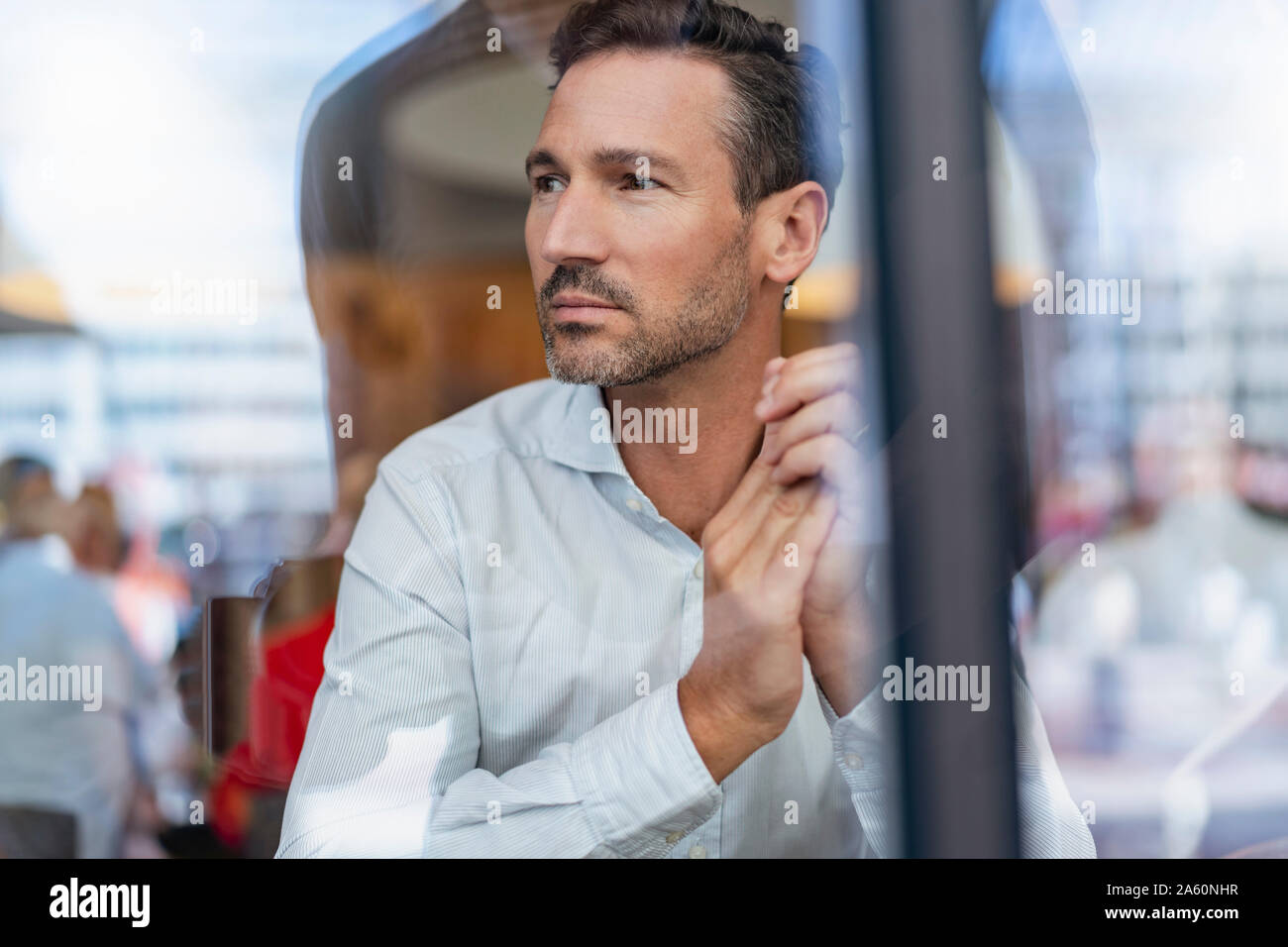 Portrait von Geschäftsmann hinter Fensterglas in einem Cafe Stockfoto