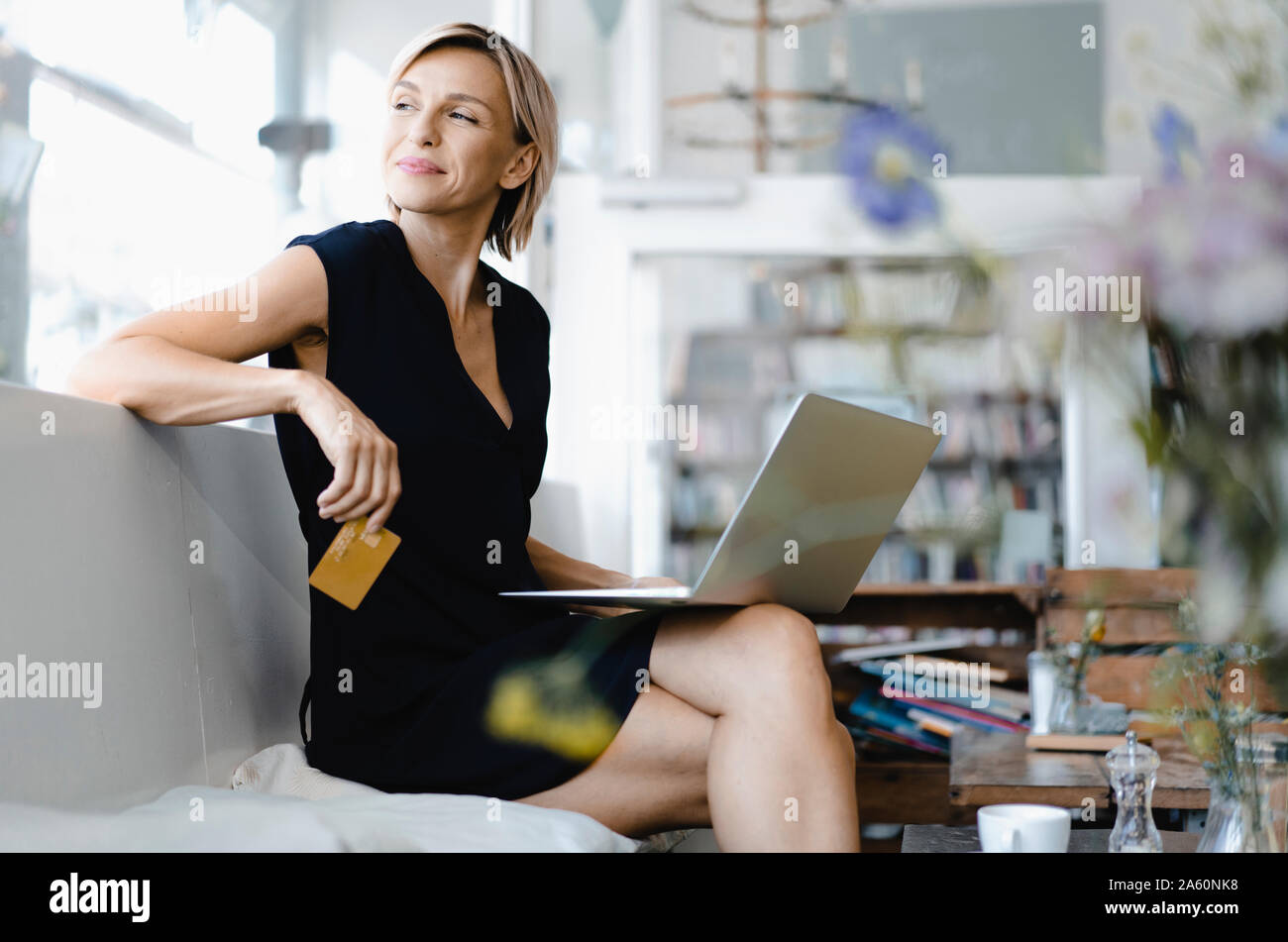 Geschäftsfrau, die online Bezahlung, im Café sitzen, mit Laptop und Kreditkarte Stockfoto