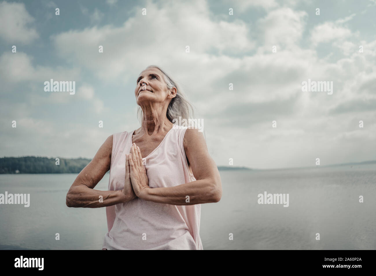 Ältere Frau Meditation am Meer Stockfoto