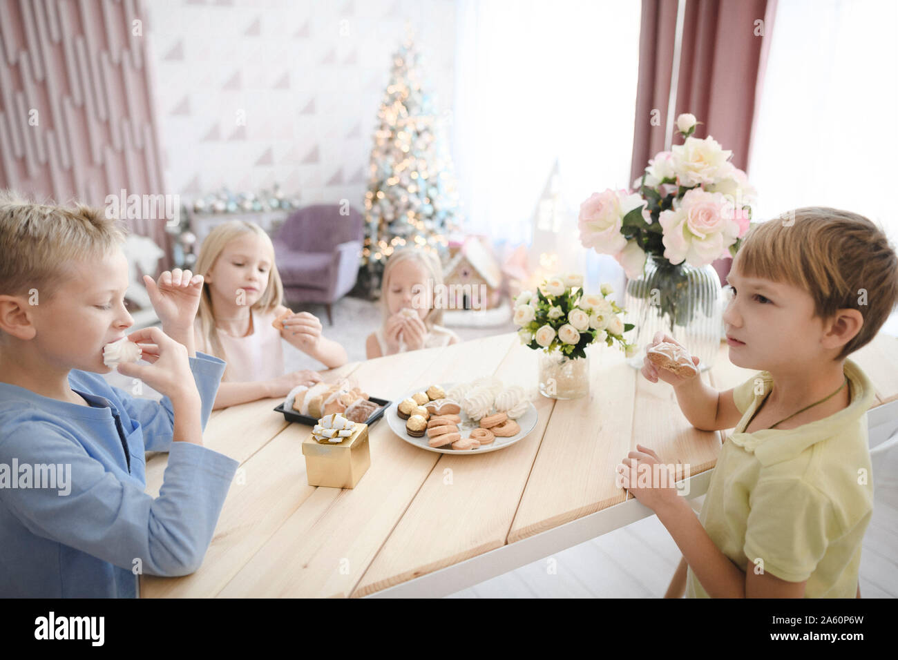 Vier Kinder essen Cookies zu Hause Stockfoto