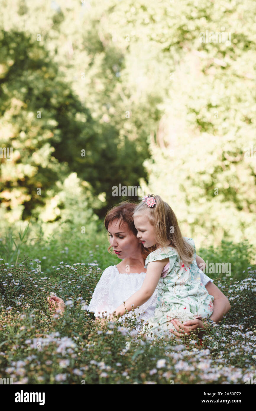 Mutter mit ihrer Tochter in einer Blumenwiese Stockfoto