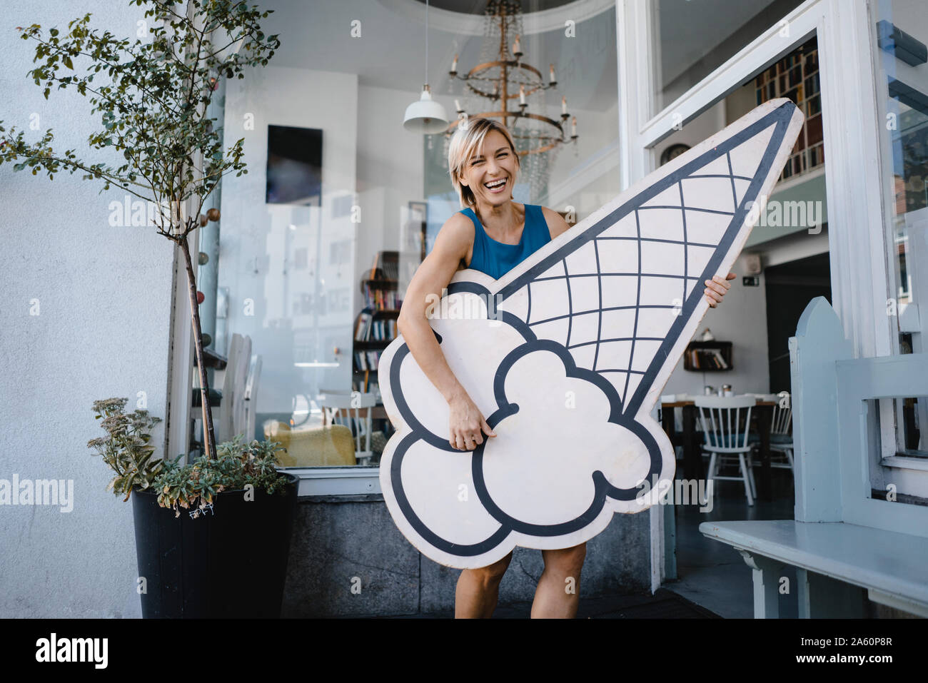 Die Frau, der vor ihr steht Coffee Shop, Holding icecream Zeichen Stockfoto