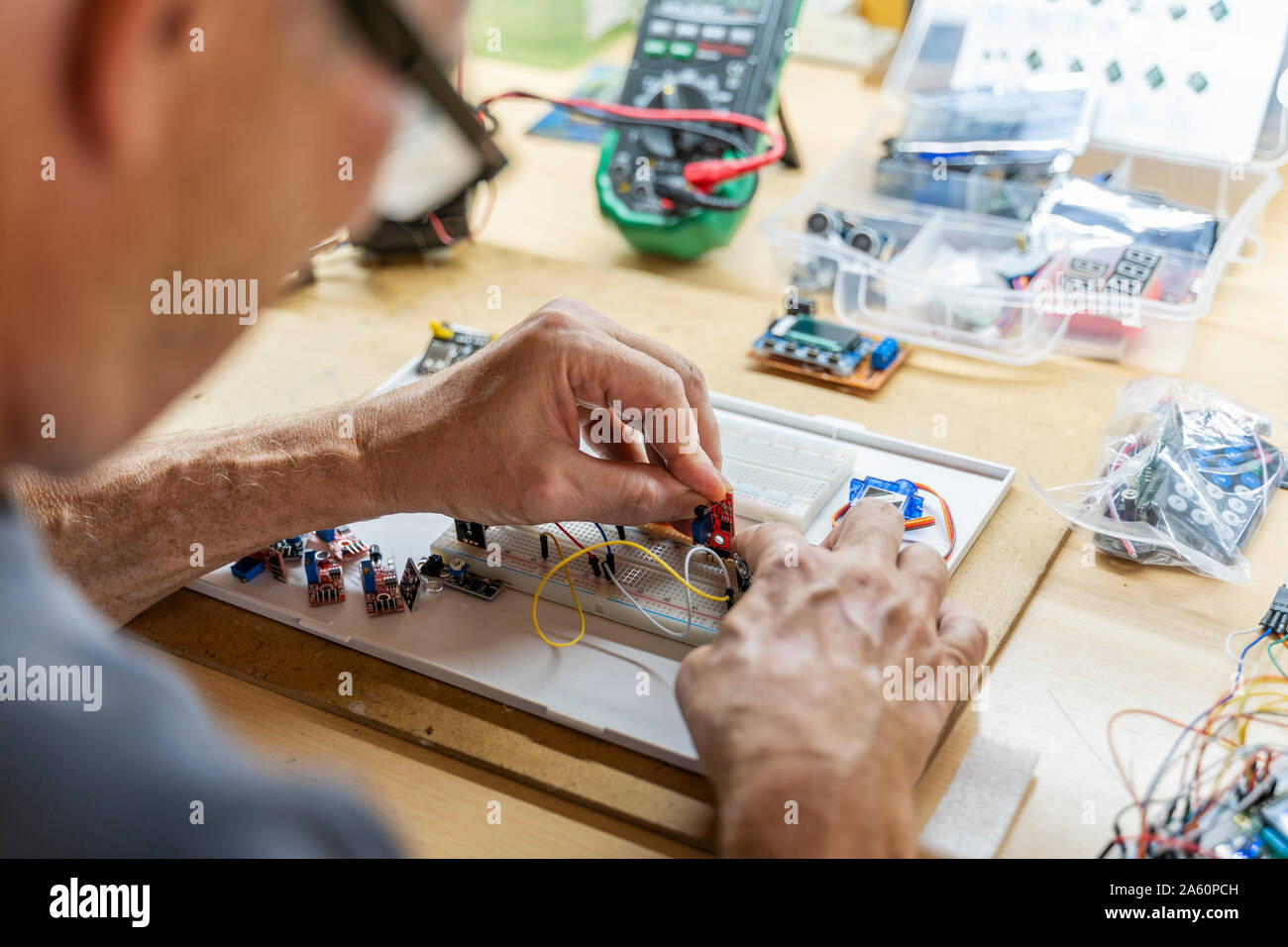 Ältere Menschen arbeiten an elektronischen Schaltungen in seiner Werkstatt Stockfoto