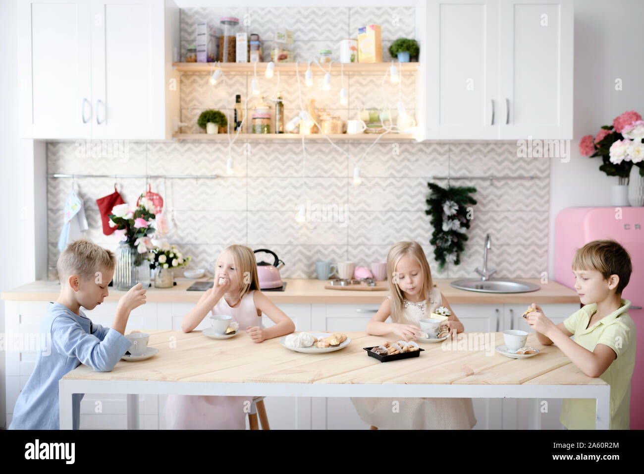 Vier Kinder, die Cookies am Küchentisch Stockfoto