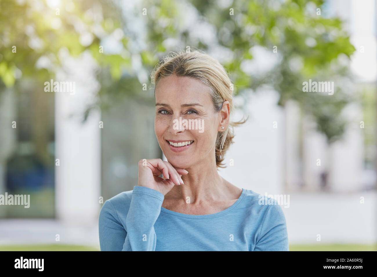 Portrait von lächelnden blonde Frau in einem Park Stockfoto