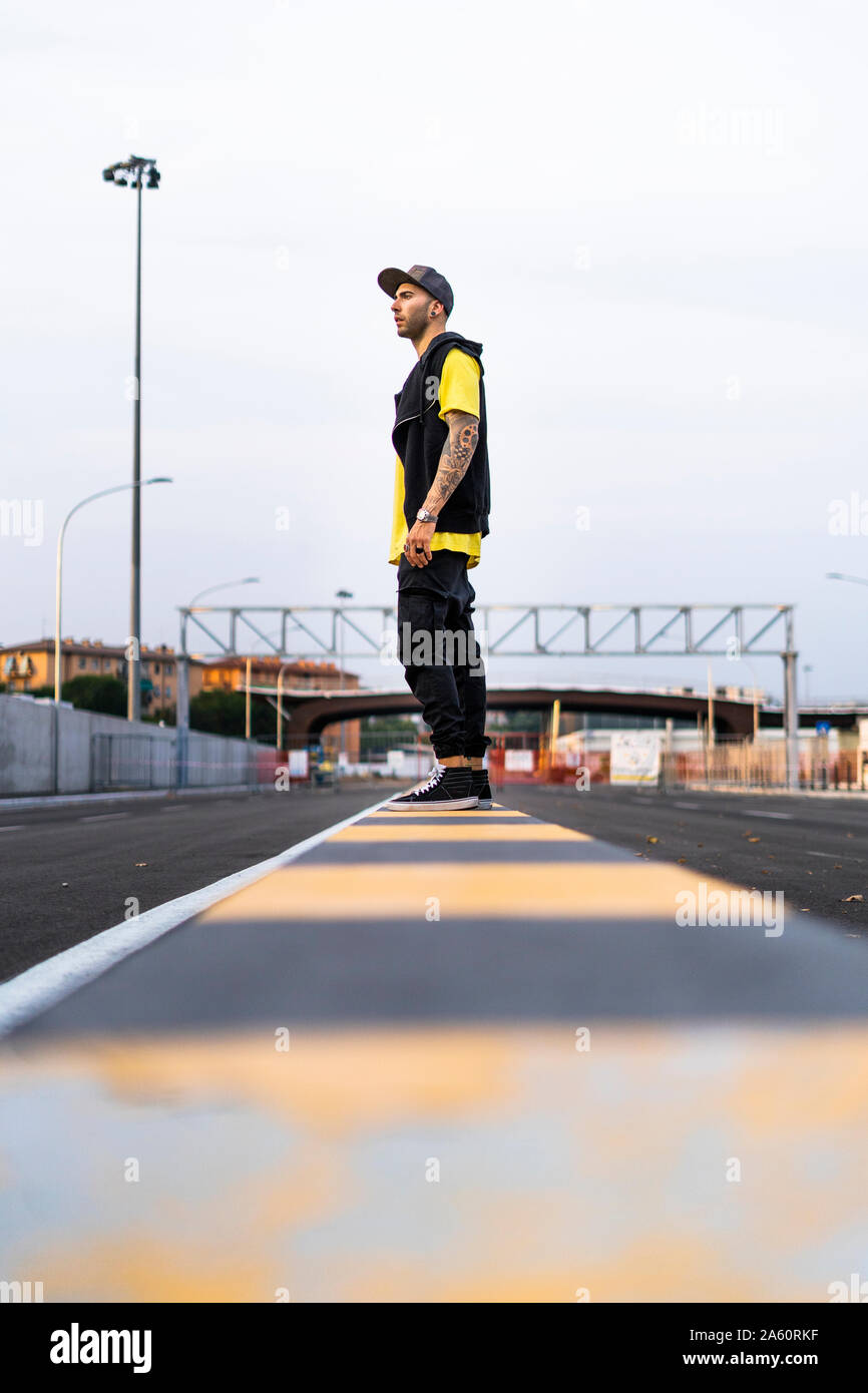 Tätowierten jungen Mann mit Baseball Cap in der Stadt Stockfoto