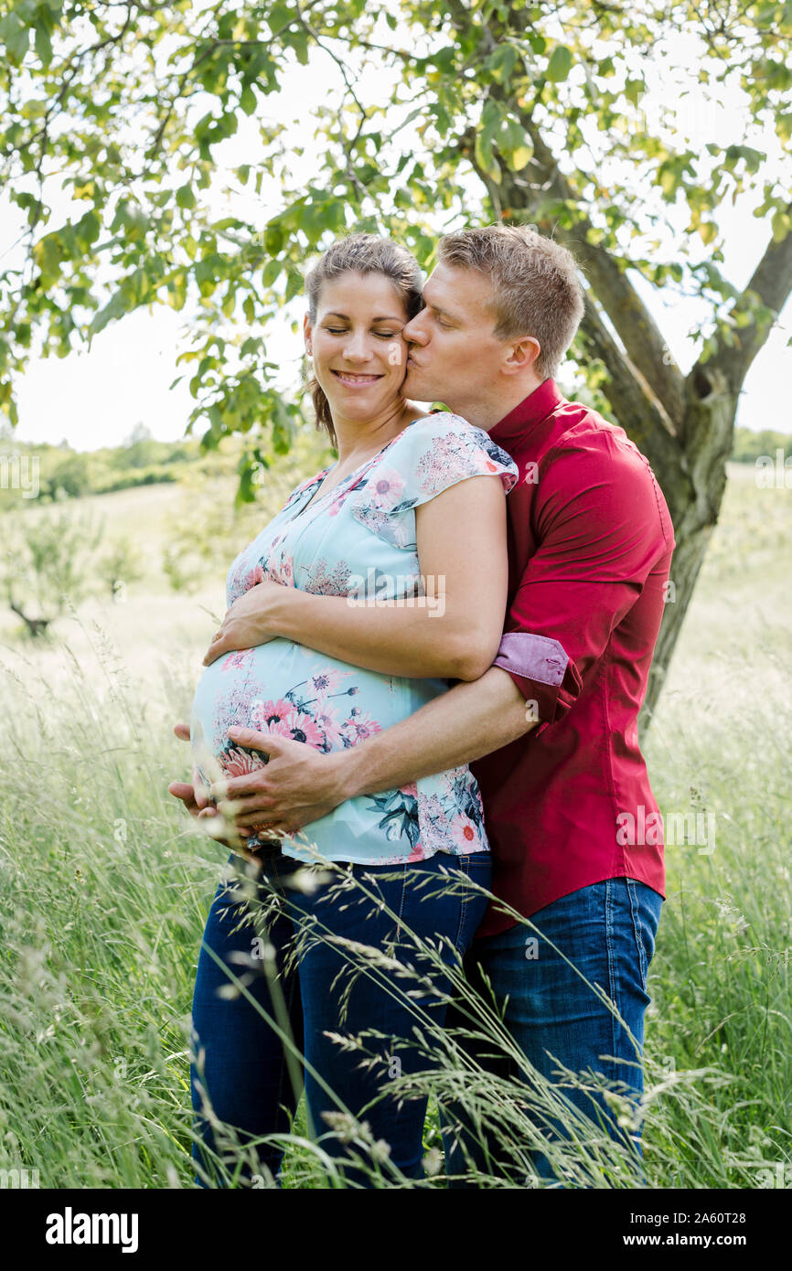 Schwangere Frau und Mann baby Holding Bauch, Mann küsste seine Frau Stockfoto