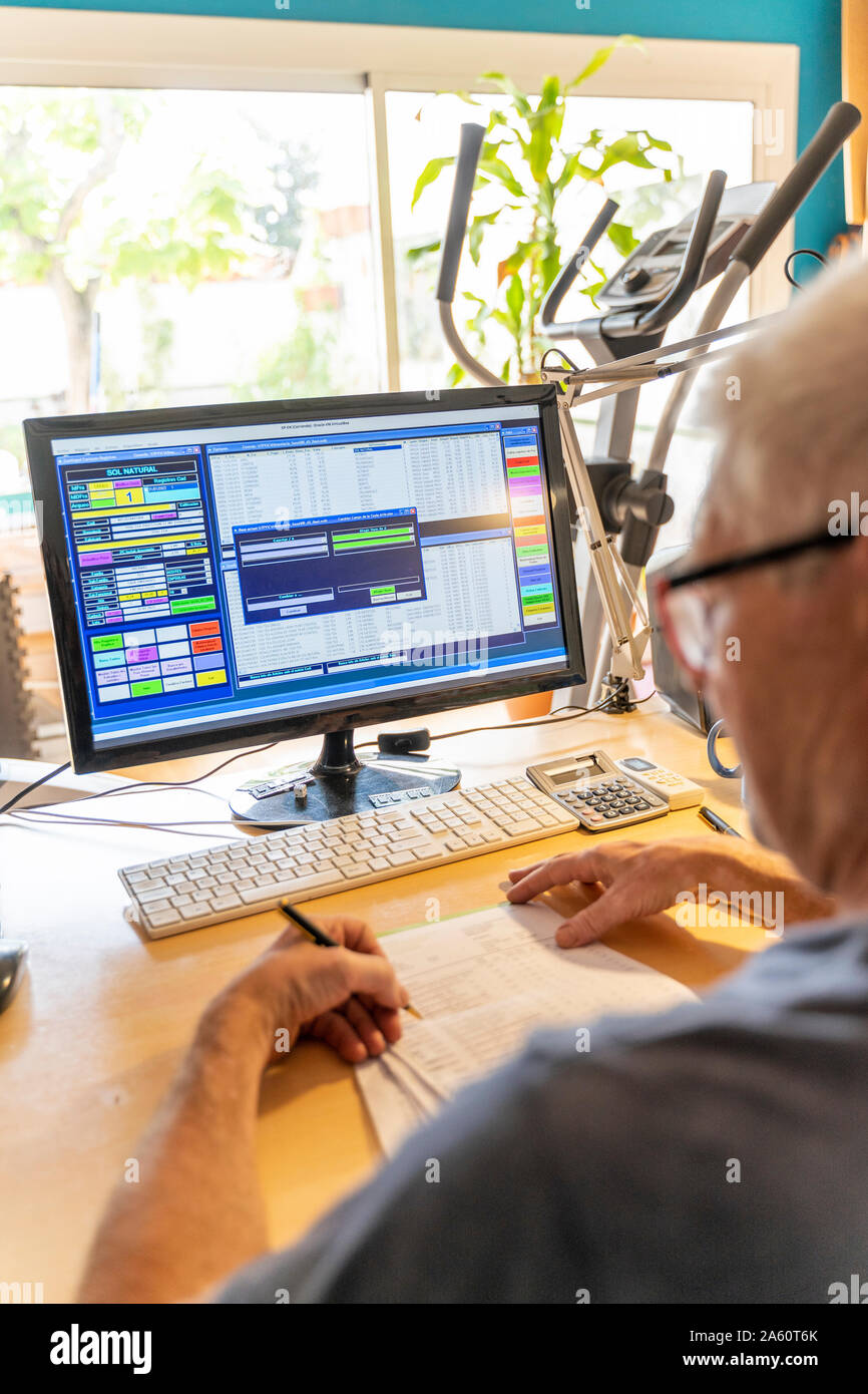 Älterer Mann bei der Arbeit im Büro mit Computer Stockfoto