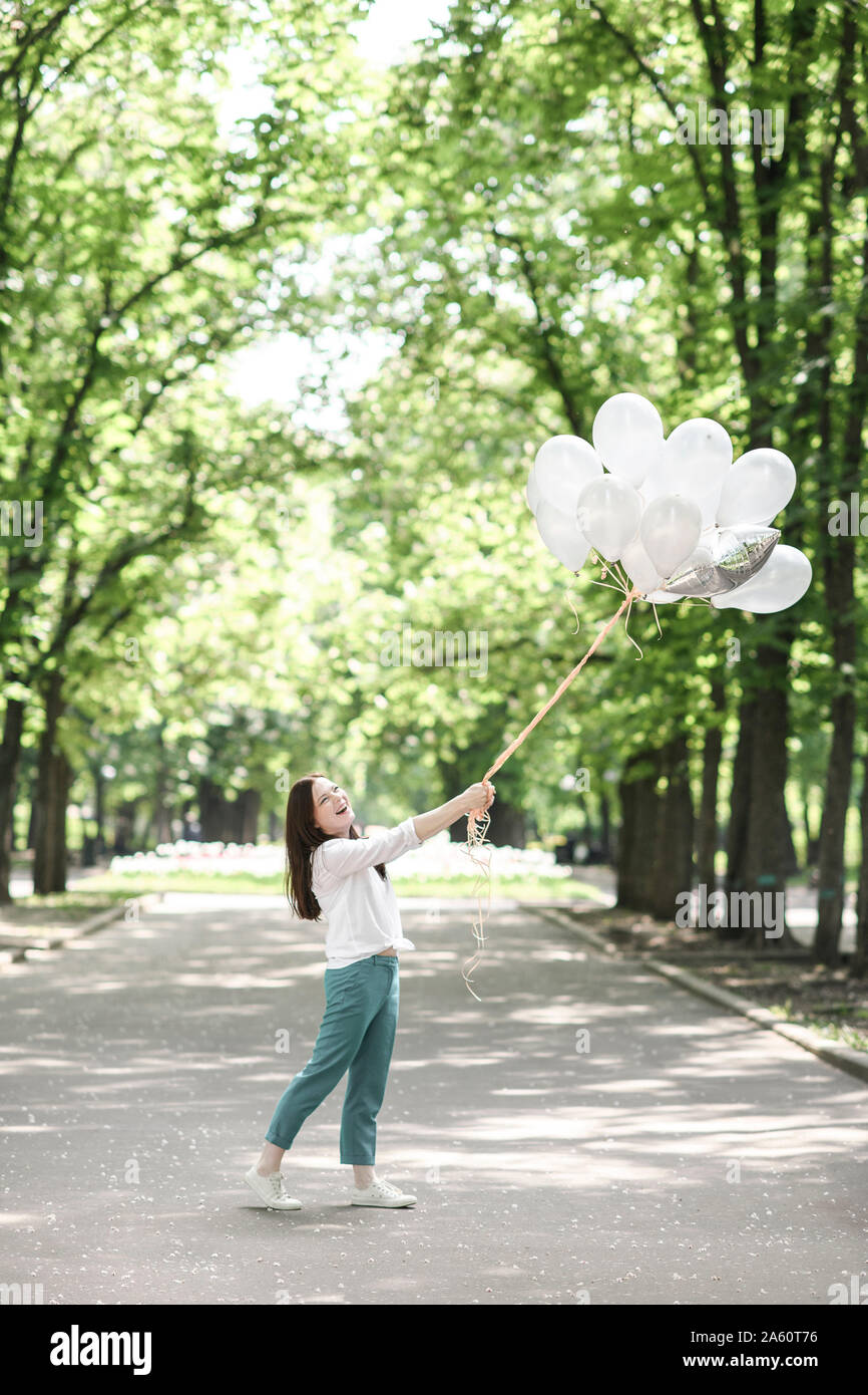 Glückliche Frau mit Ballons in einem Park Stockfoto