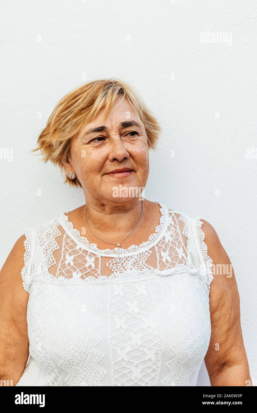 Porträt einer älteren Frau mit einem weißen Wand Hintergrund Stockfoto