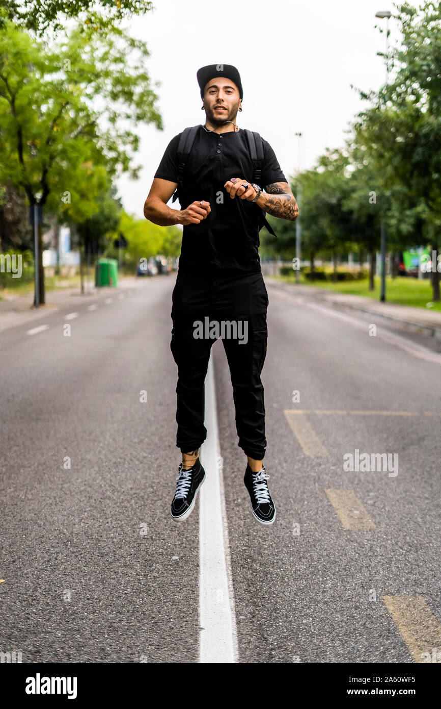 Junger Mann, springen in die Luft, auf einer Straße Stockfoto