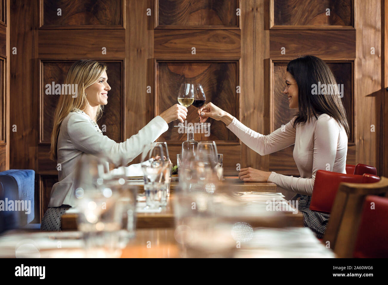Zwei Geschäftsfrauen klirren Gläser in einem Restaurant Stockfoto