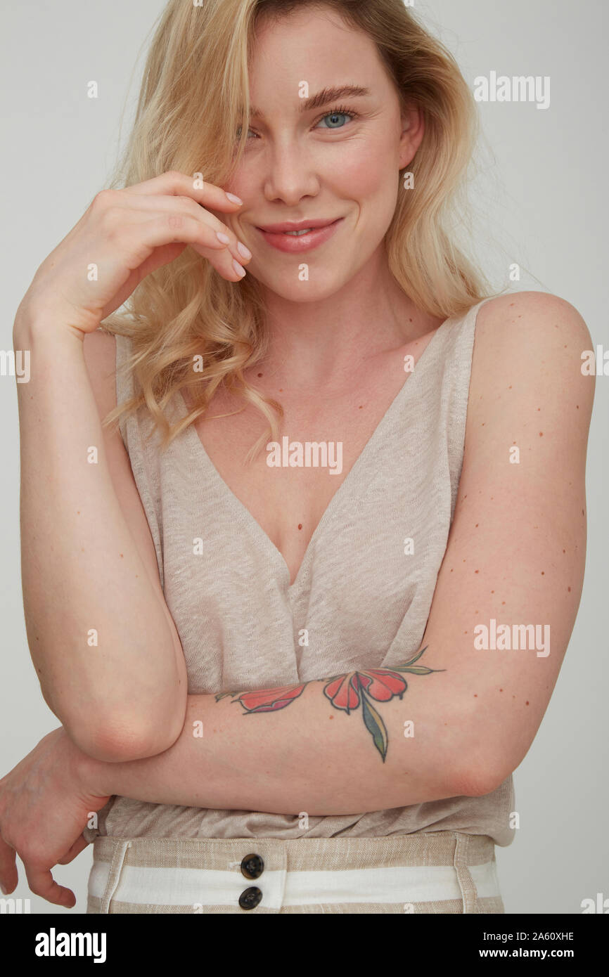 Portrait von lächelnden blonde Frau mit Tattoo am Unterarm Stockfoto