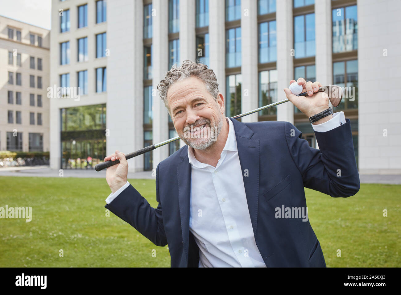 Portrait von Happy reife Geschäftsmann mit Golf Club in der Stadt Stockfoto