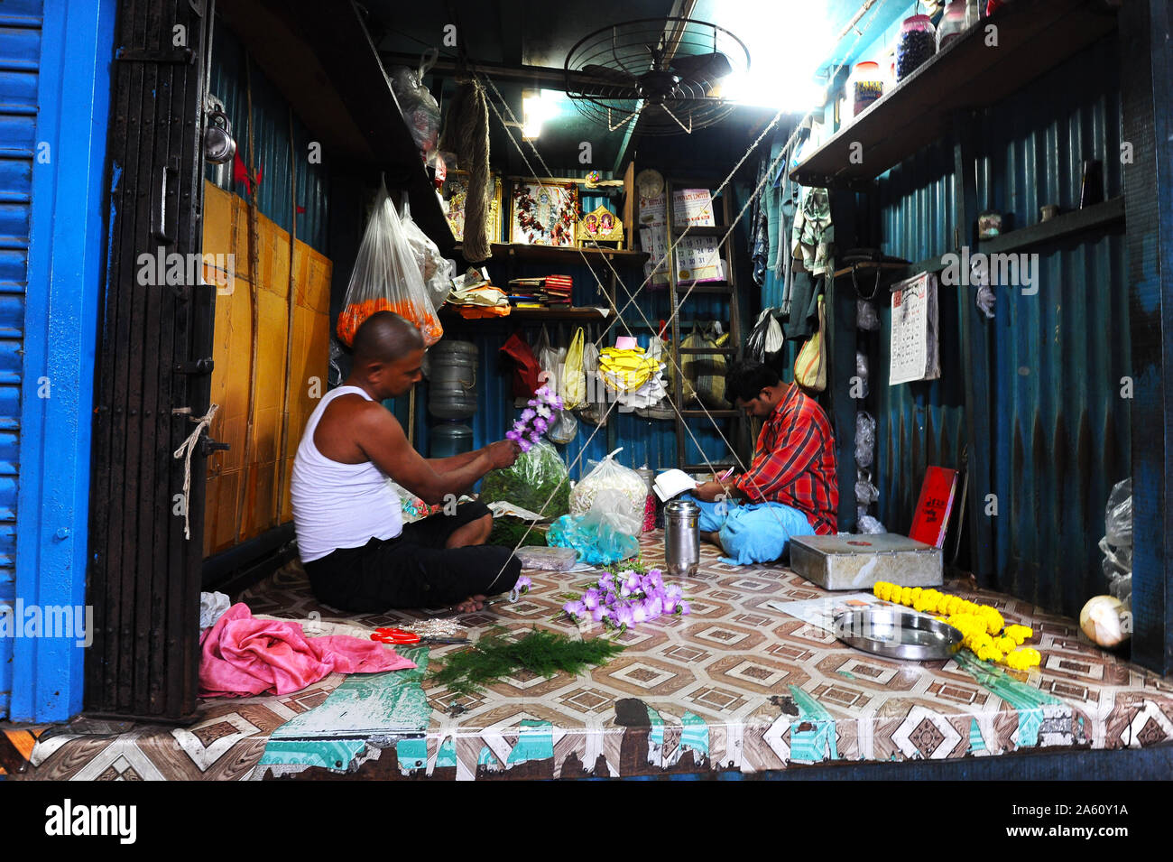 Zwei Männer in Malik Ghat Blumenmarkt threading floralen Girlanden, Kolkata, West Bengal, Indien, Asien Stockfoto