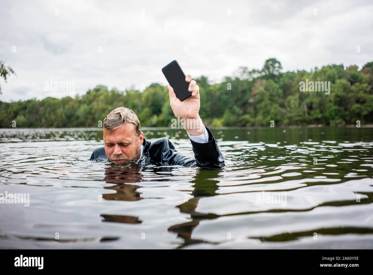 Geschäftsmann mit Mobiltelefon in einem See Stockfoto