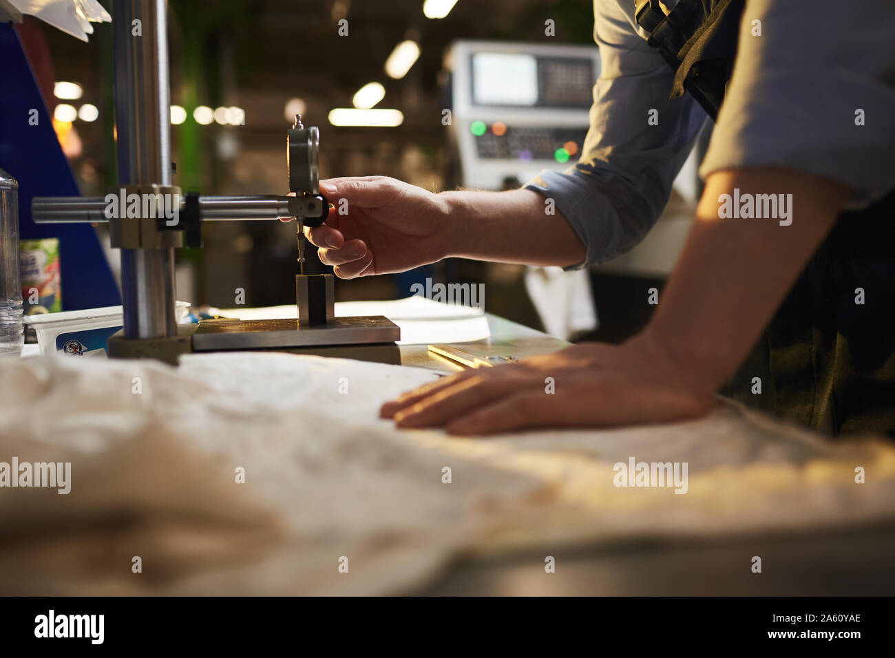 Nahaufnahme der Arbeiter in der Nähe von der Drehmaschine und arbeitet daran, die er produziert Details in der Anlage Stockfoto