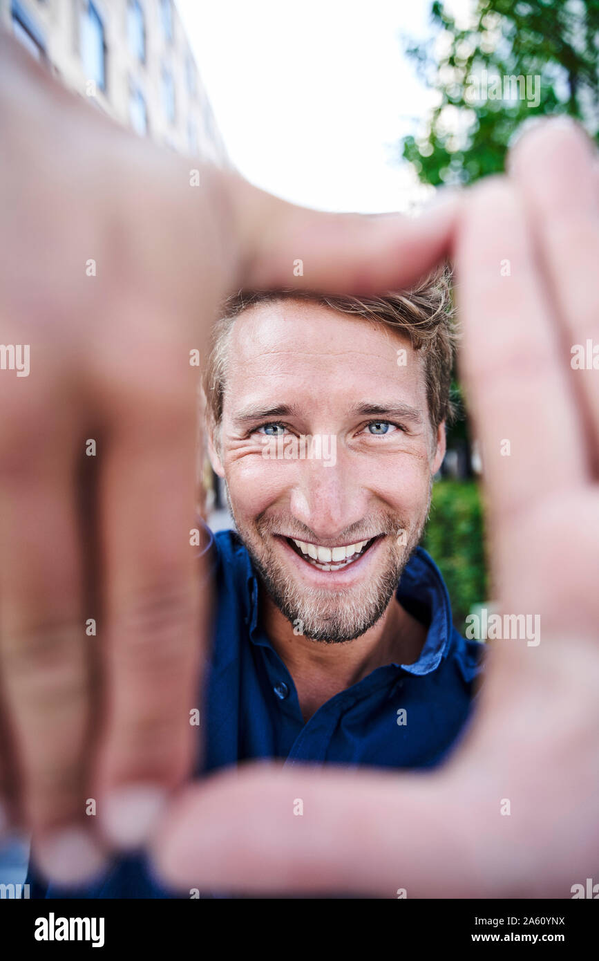Porträt der glückliche junge Mann, der mit einem Finger frame Stockfoto
