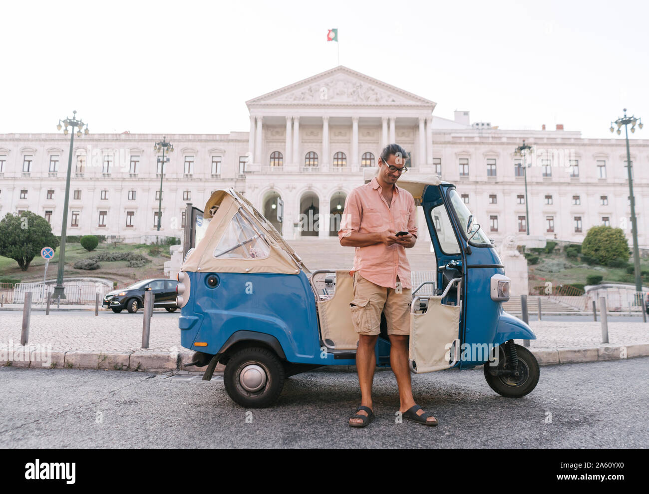 Tuk Tuk Fahrer in der Stadt smartphone, Lissabon, Portugal Stockfoto