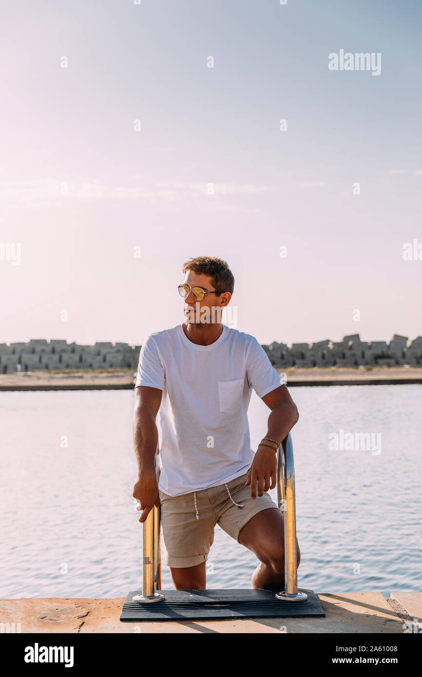 Junger Mann auf einem Pier am Schwimmbad Stockfoto