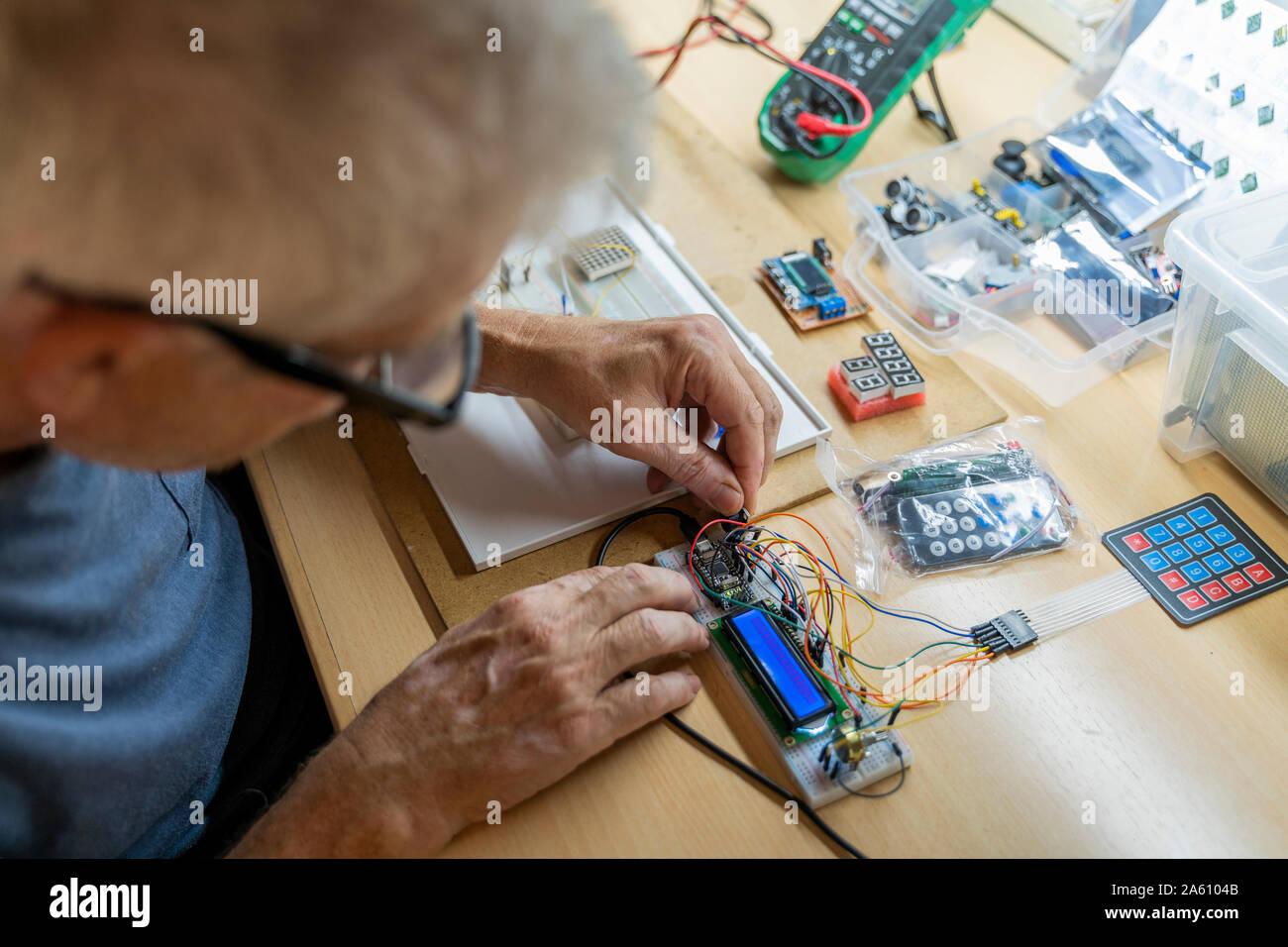 Ältere Menschen arbeiten an elektronischen Schaltungen in seiner Werkstatt Stockfoto