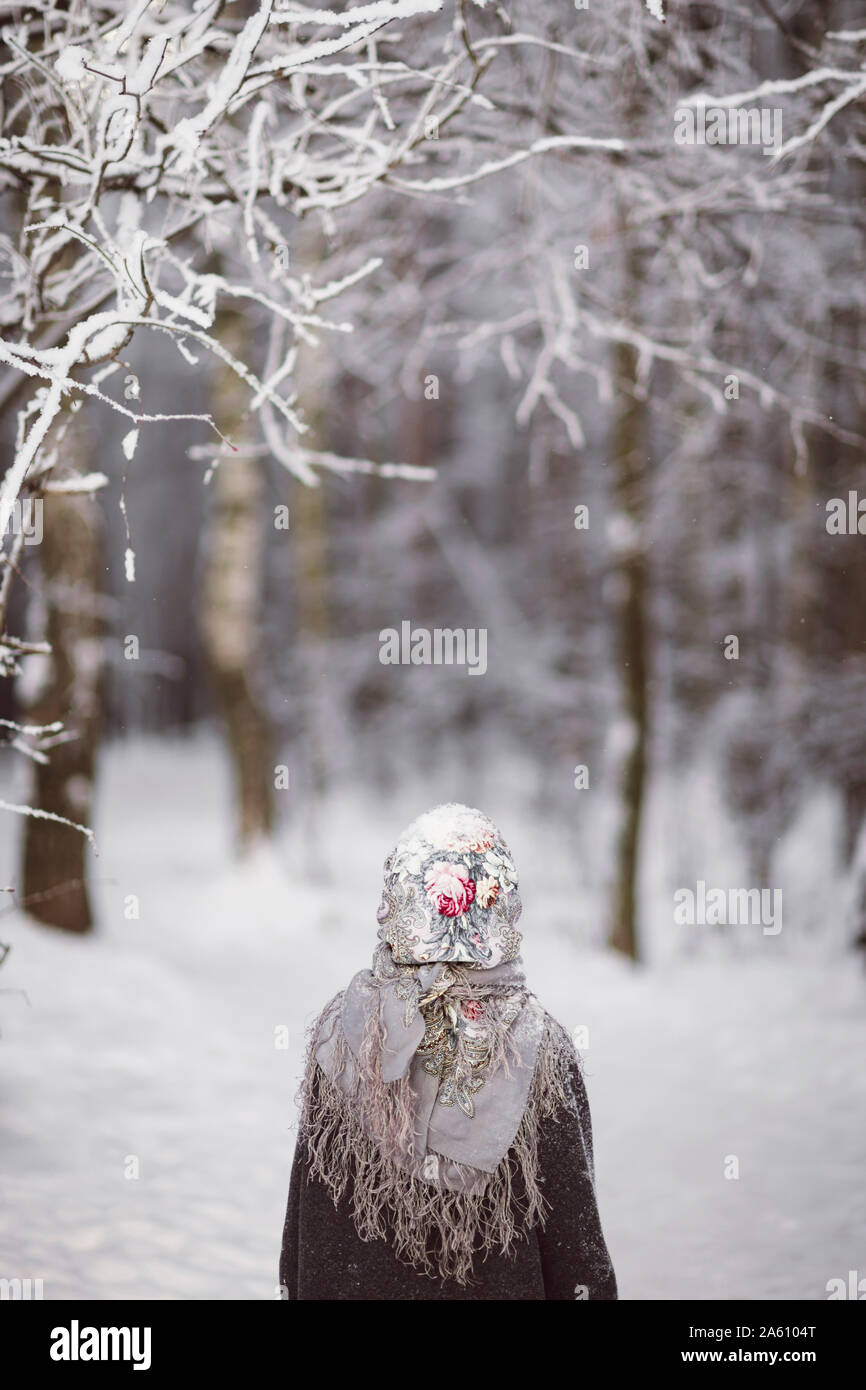Zurück Blick auf kleine Mädchen mit Kopftuch vor Winter Forest Stockfoto