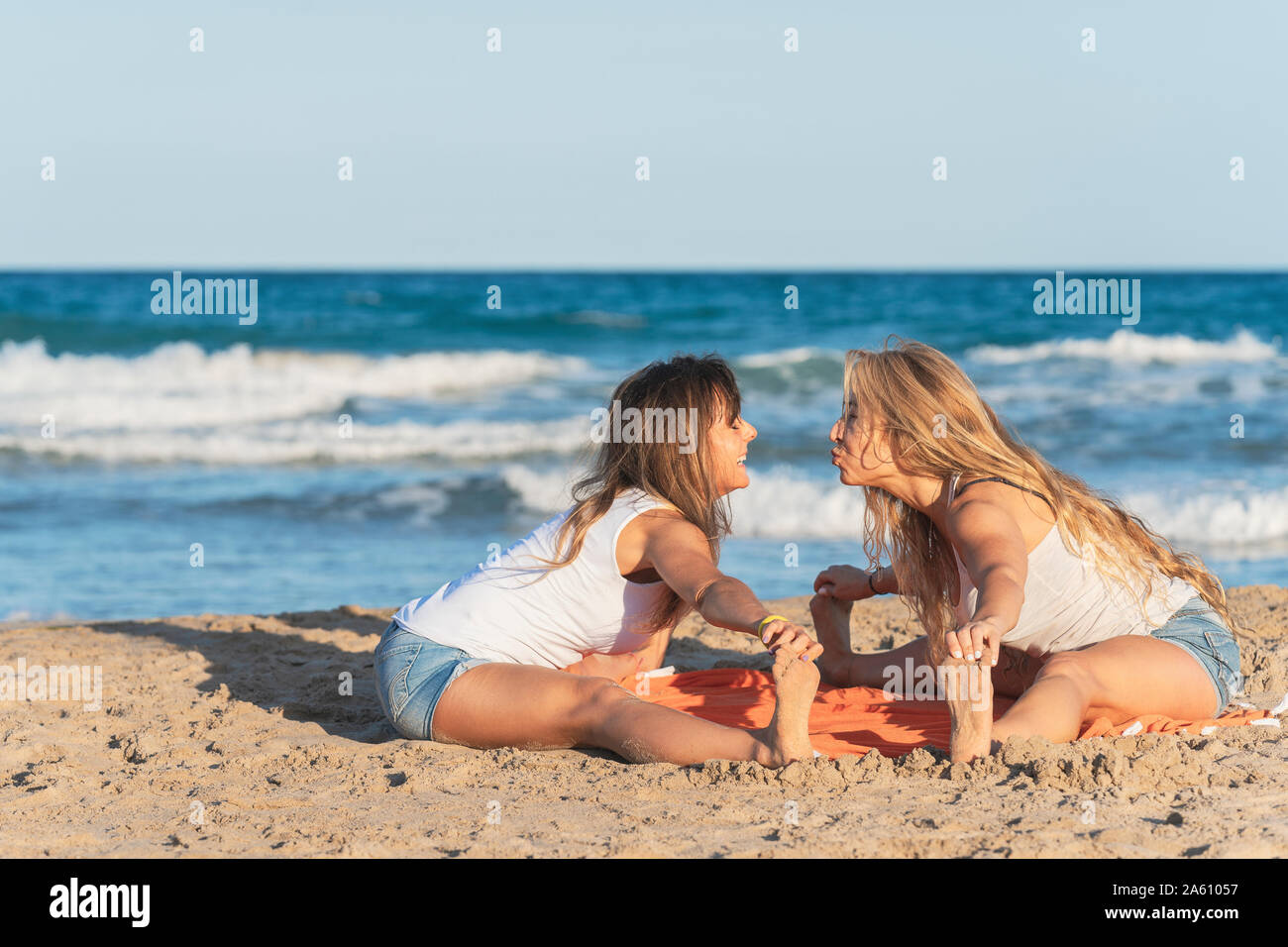 Zwei Frauen praticing Acro Yoga am Strand Stockfoto