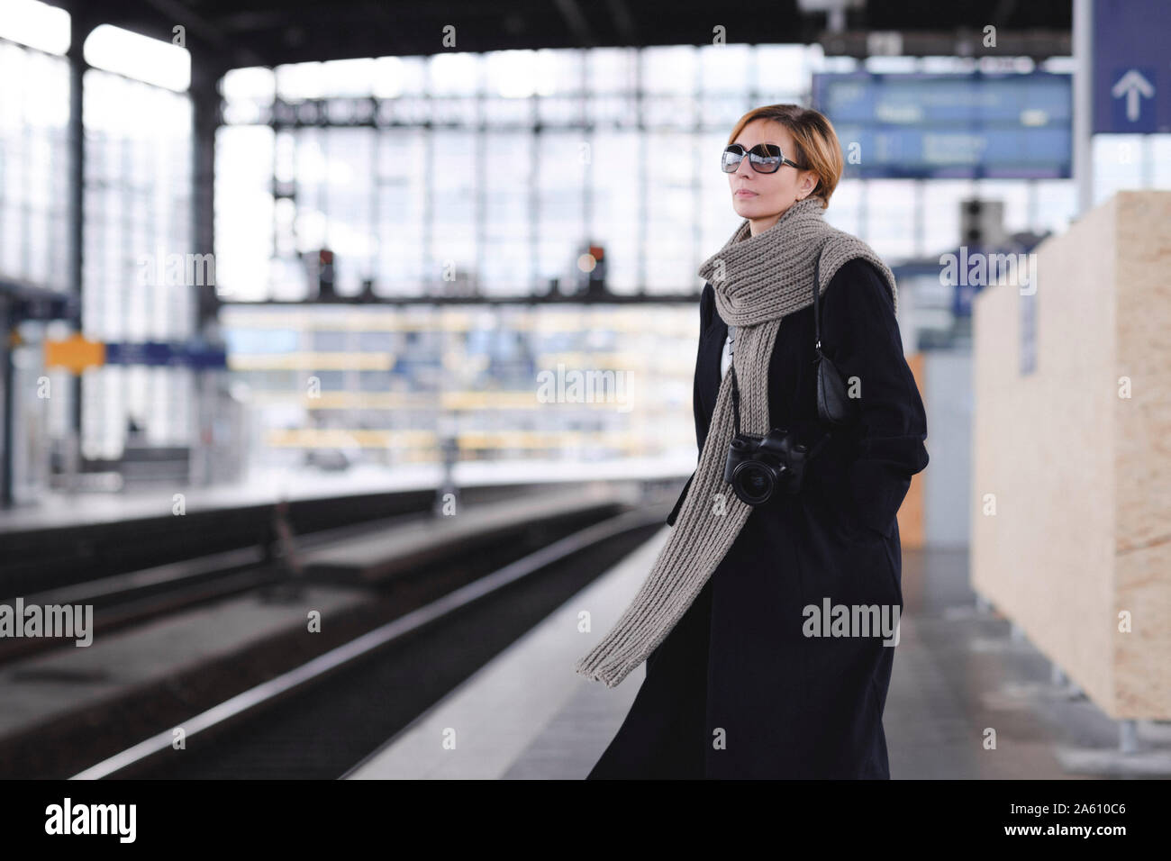 Reife Frau mit Kamera mit schwarzen Fell und große Wolle Schal an Plattform warten Stockfoto