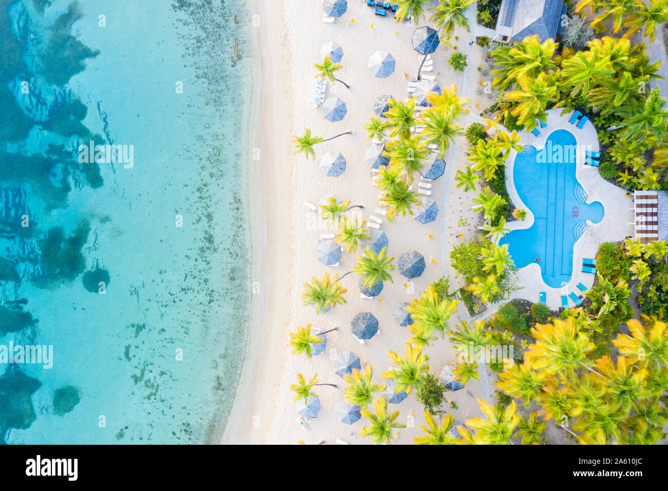 Pool und Strand Sonnenschirme am weißen Sandstrand von oben von Drohne, Morris Bay, alte Straße, Antigua, Leeward Inseln, West Indies, Karibik Stockfoto