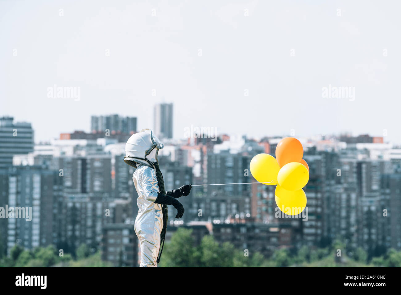 Junge gekleidet wie ein Astronaut holding Ballons in der Stadt Stockfoto