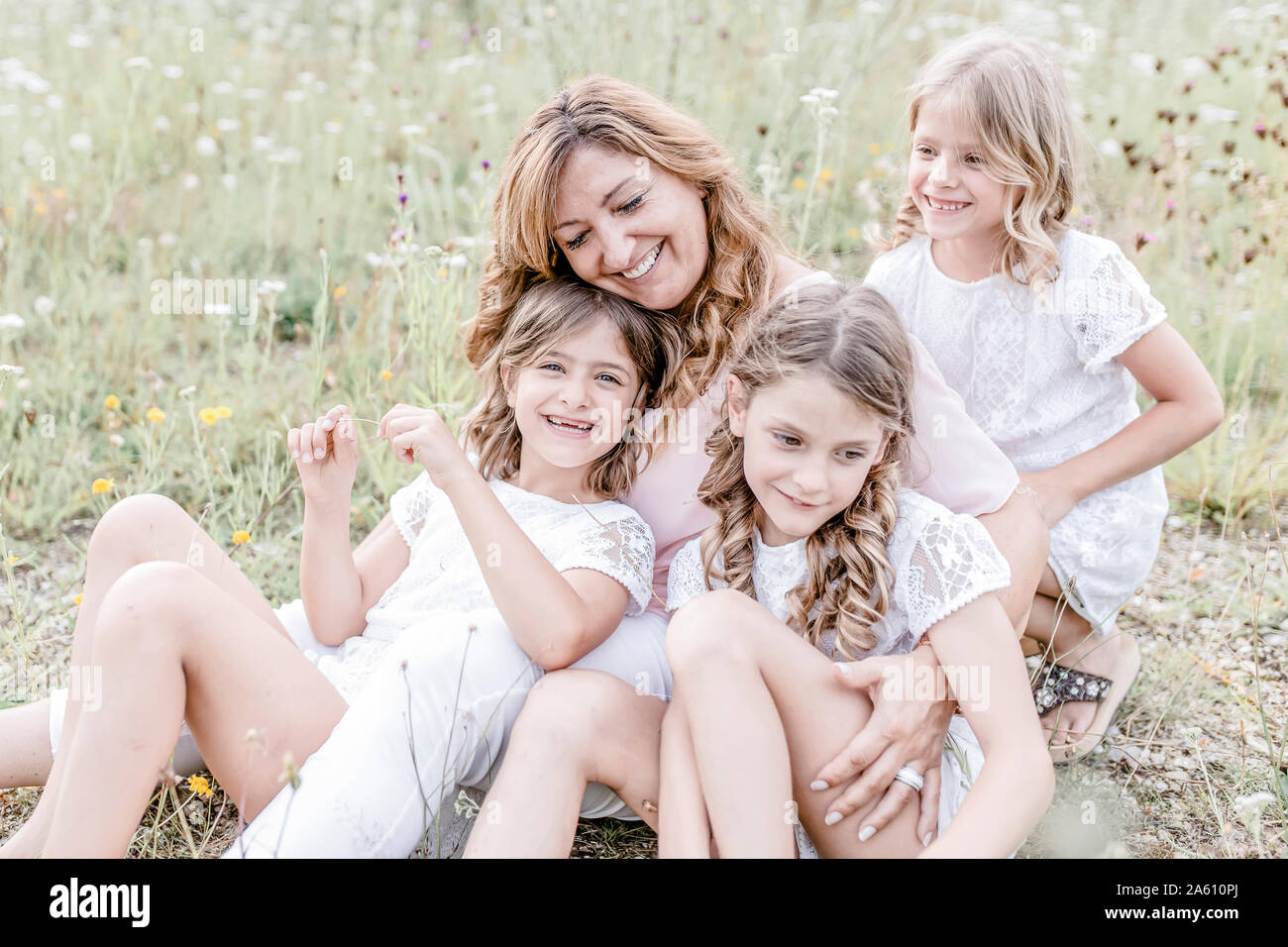 Glückliche Mutter mit drei Triplet Töchter in einem Feld Stockfoto