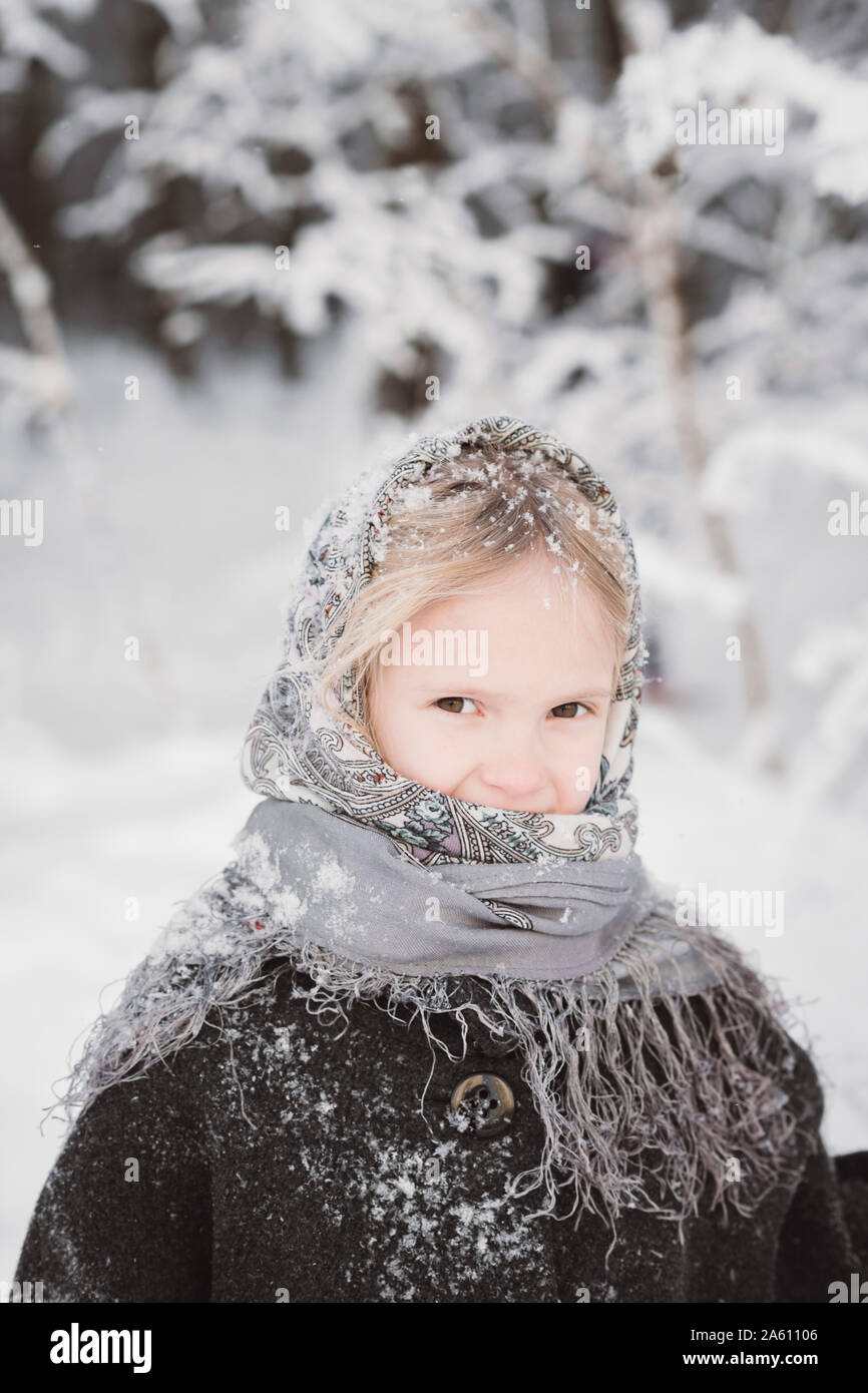 Portrait von schneebedeckten kleines Mädchen im Winter Wald Stockfoto