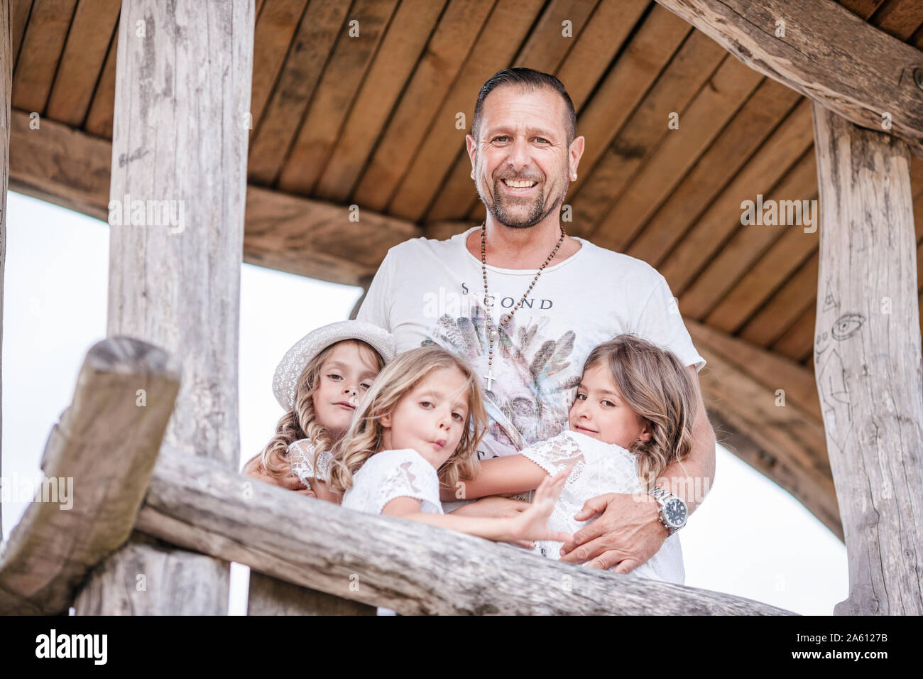 Gerne Vater mit drei Triplet Schwestern in einem Baumhaus Stockfoto