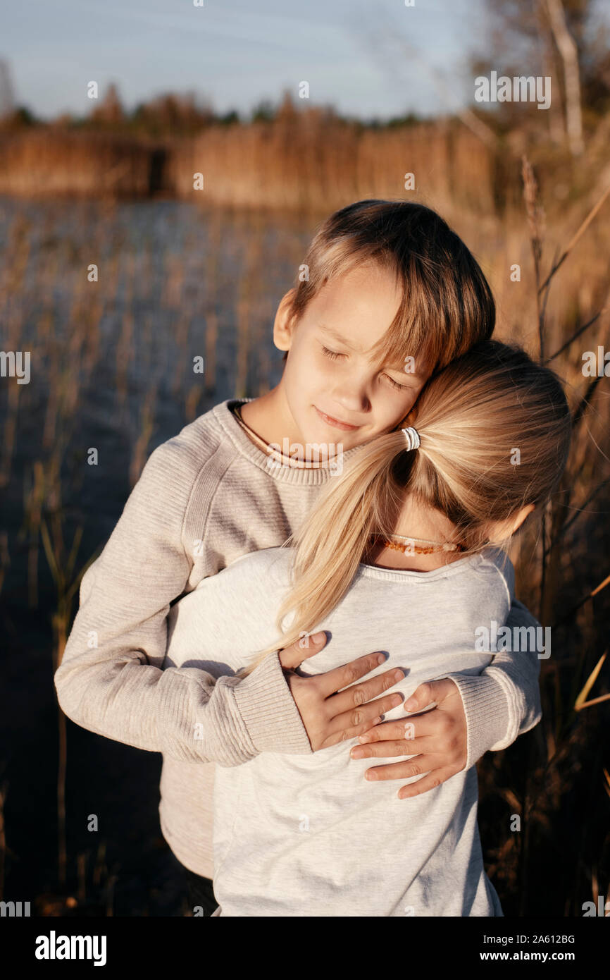 Portrait der Boy seine kleine Schwester umarmen in der herbstlichen Natur Stockfoto