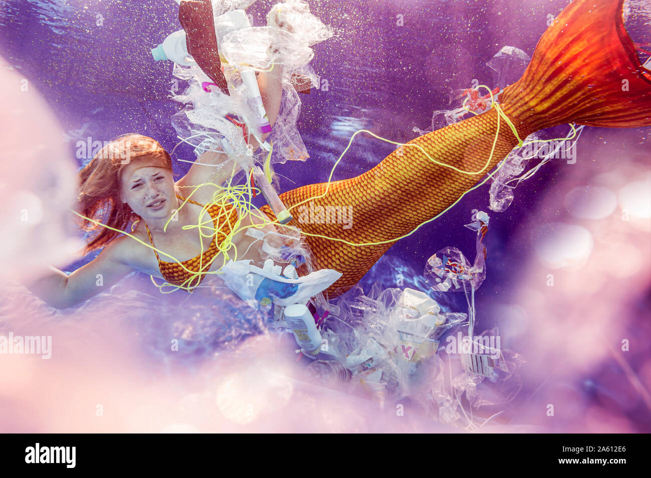 Teenage Meerjungfrau Girl von Kunststoffabfällen umgeben unter Wasser Stockfoto