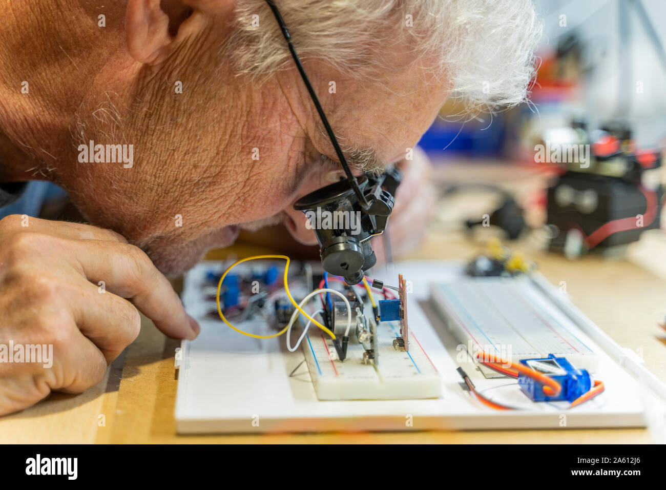 Ältere Menschen arbeiten an elektronischen Schaltungen in seiner Werkstatt Stockfoto