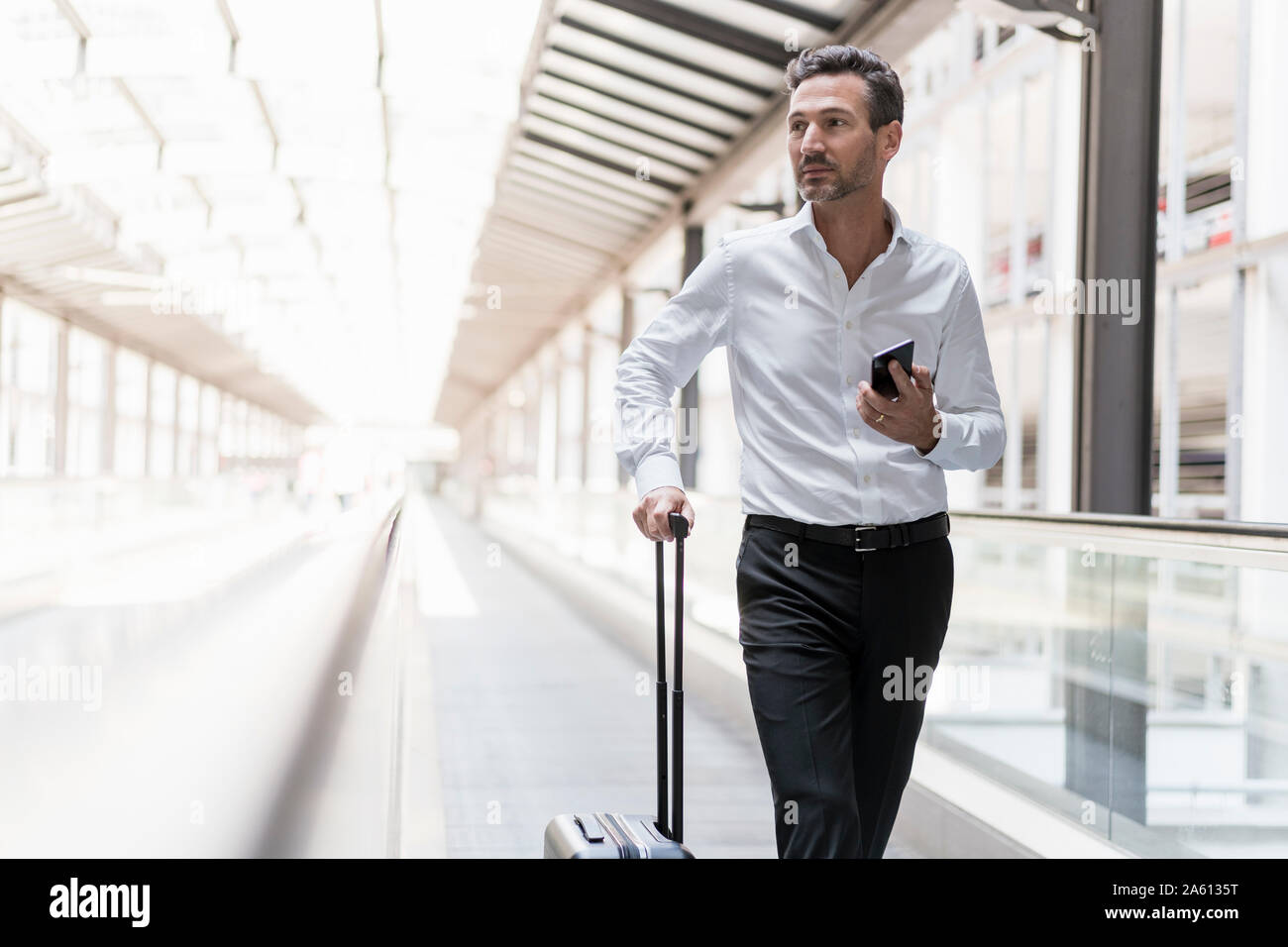 Geschäftsmann auf fahrsteig am Flughafen Stockfoto