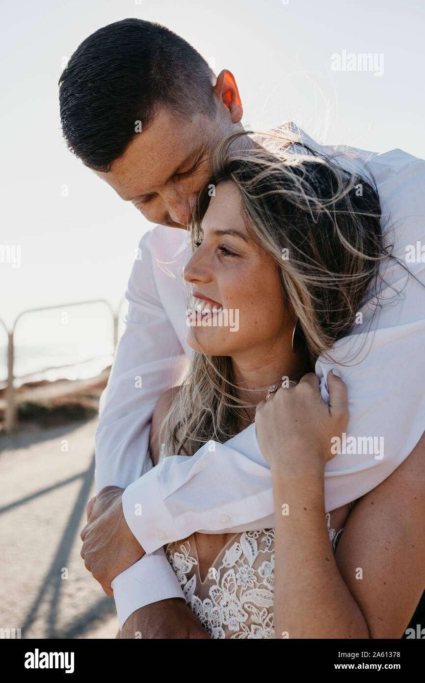Glückliche Braut und Bräutigam umarmen im Freien Stockfoto