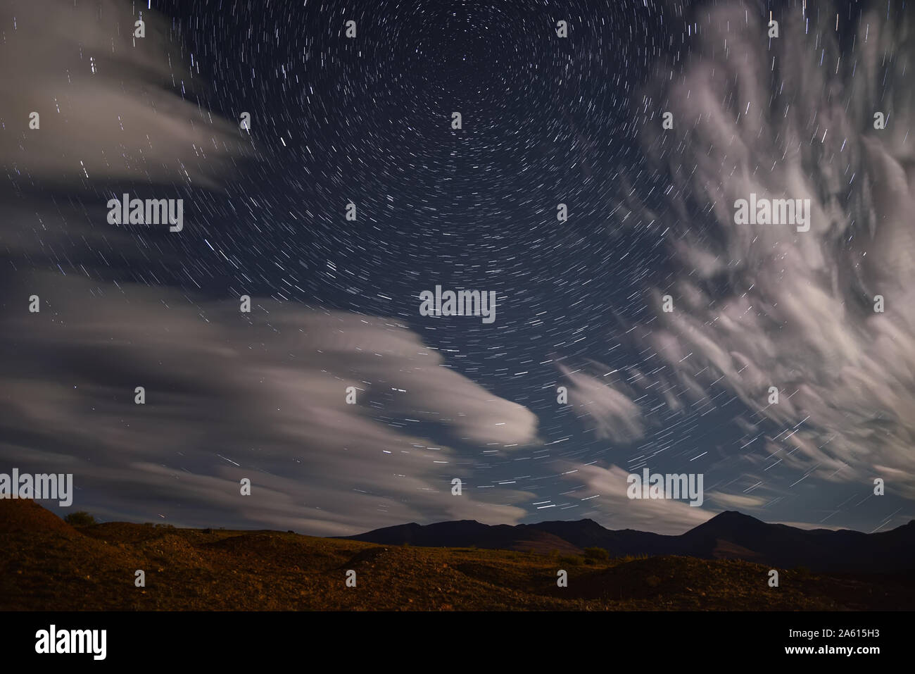 Tolle Nacht Landschaft mit der Bewegung der Sterne in der Form von Titel und Wolken im Himmel über den Bergen Stockfoto