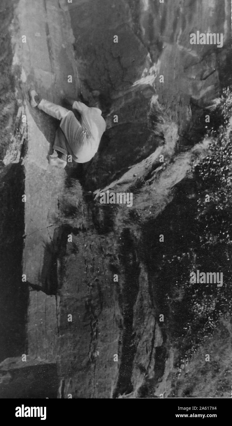 Ein Mann klammert sich während einer Northern Cavern an eine Felswand und Fiel Club Rock Climbing and Spelunking Event in Yorkshire, Großbritannien, 1934. () Stockfoto