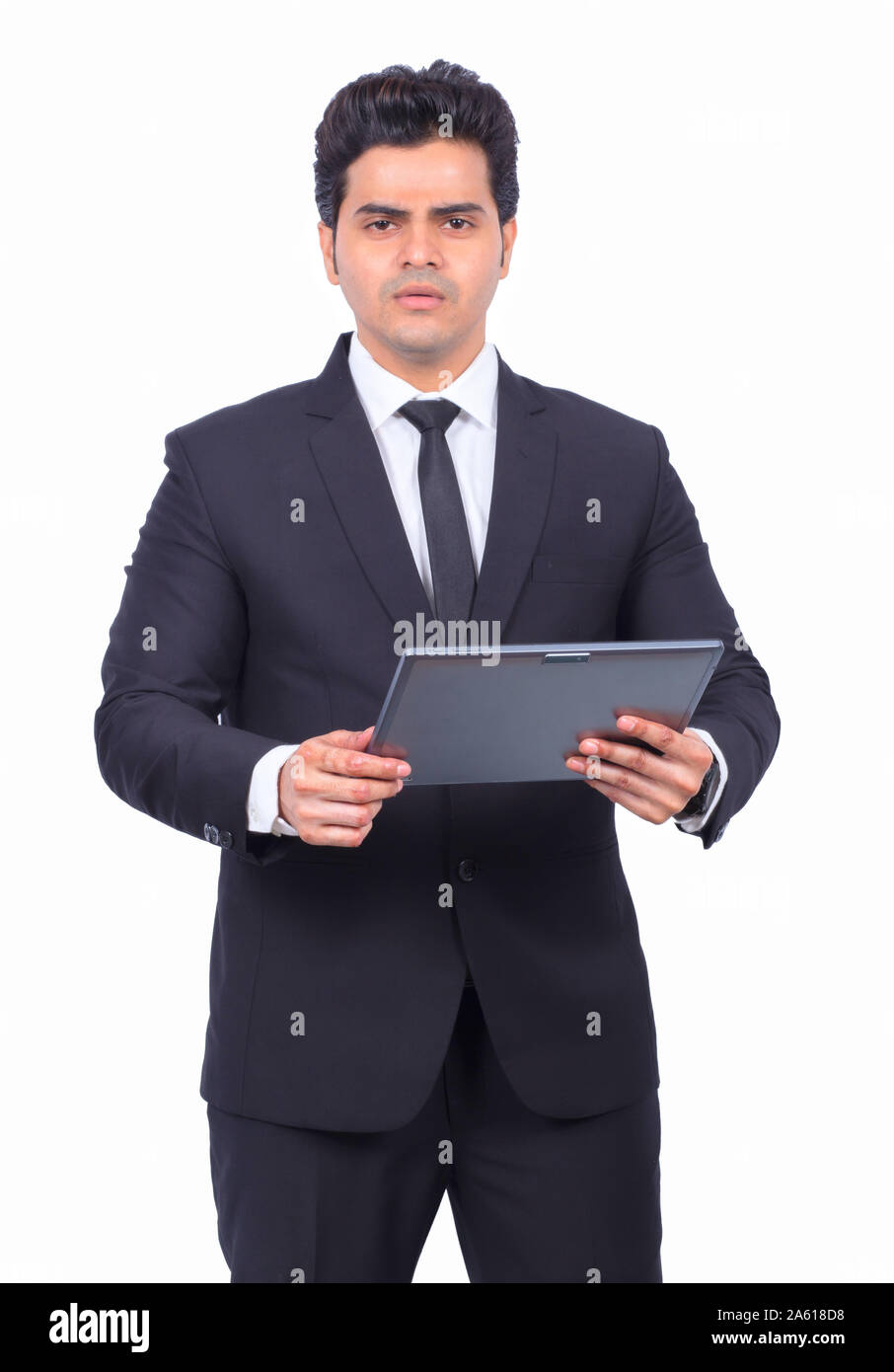 Portrait von stattlicher Junge Unternehmer halten digitale Tablet. Männliche Professional ist über die drahtlose Computer. Er trägt Anzug auf weißem Hintergrund. Stockfoto