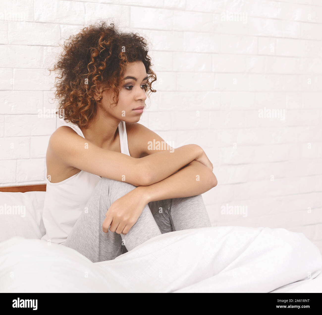 Deprimiert schwarze Frau im Bett sitzen und denken über ihre Probleme Stockfoto