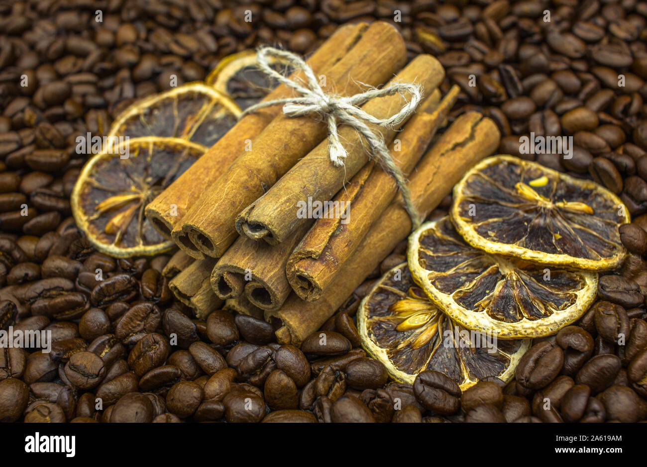 Cinnamon Sticks mit Scheiben getrocknete Orangen auf einem Bett von Kaffeebohnen Stockfoto