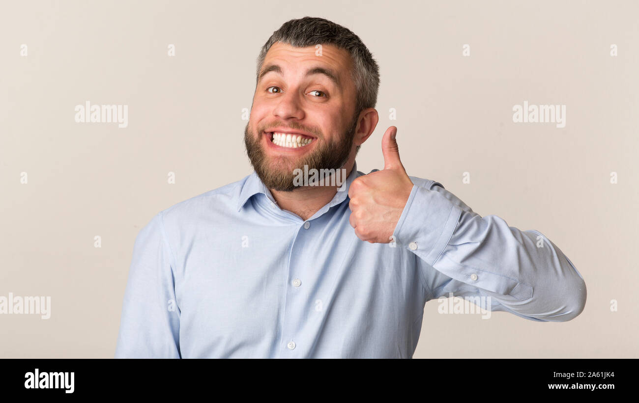 Happy bärtiger Mann mit Daumen hoch und lächelte Studio Stockfoto