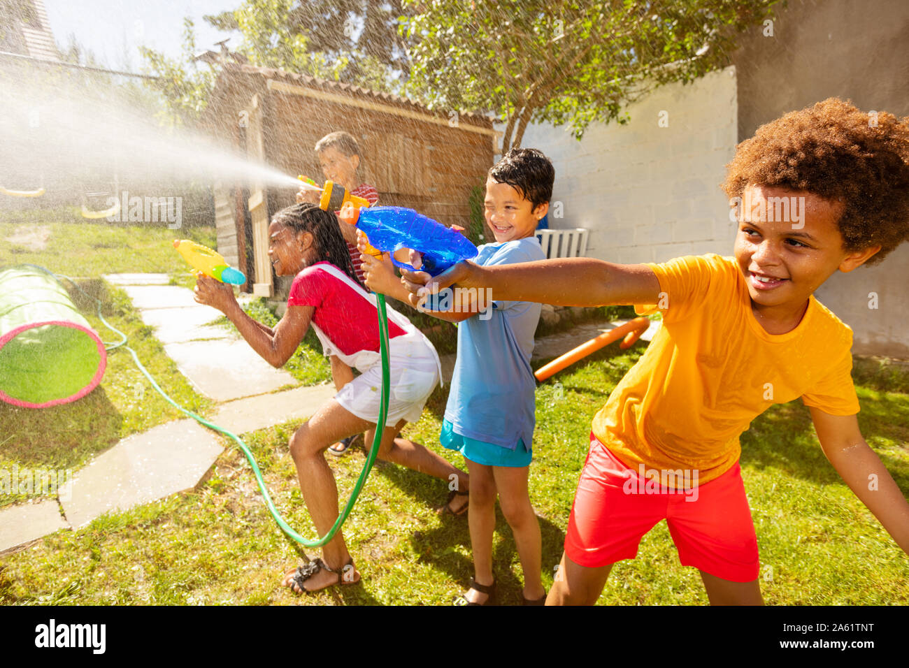 Jungen, die in der Mitte des Wassers Gun Fight action spiel Stockfoto