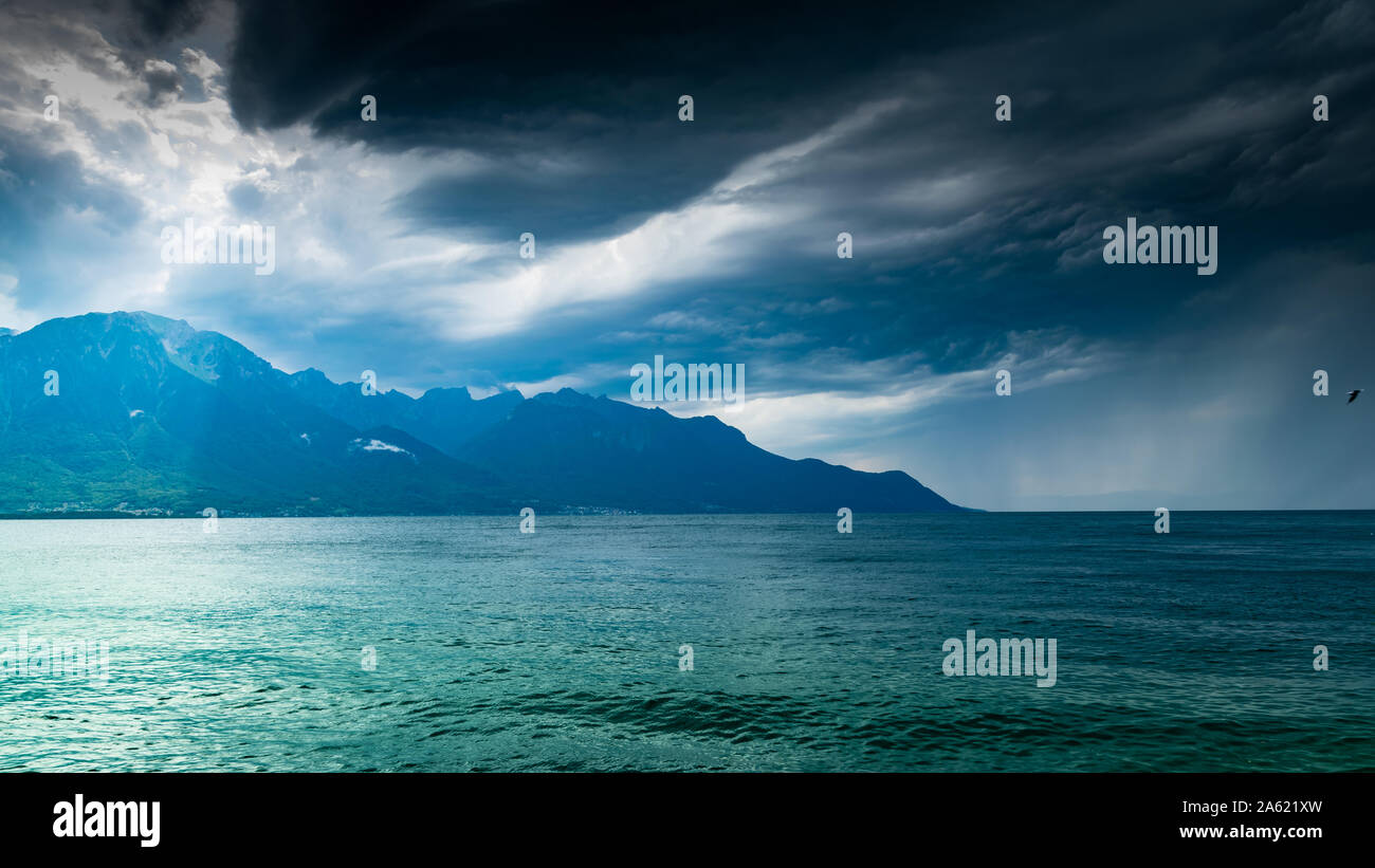 Landschaft der Alpen, Genfer See, dunklen Himmel bewölkt mit Regen in der Ferne. Schuss aus dem Ufer des Sees in Montreux, Schweiz. Stockfoto