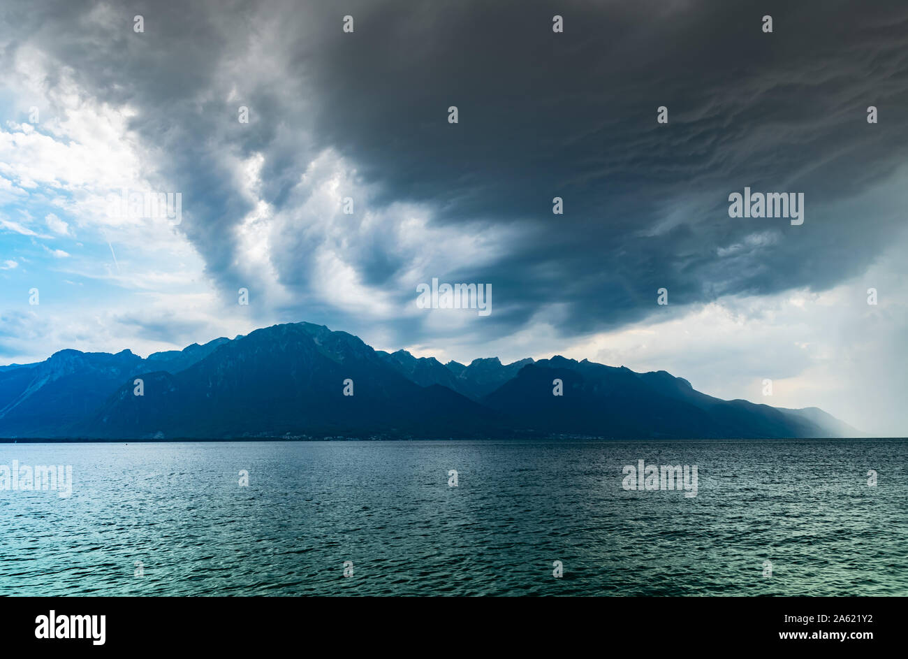 Blick auf die Alpen, den Genfer See und dunkle Regenwolken vor Regen. Schuß vom Ufer des Sees in Montreux, Schweiz. Stockfoto