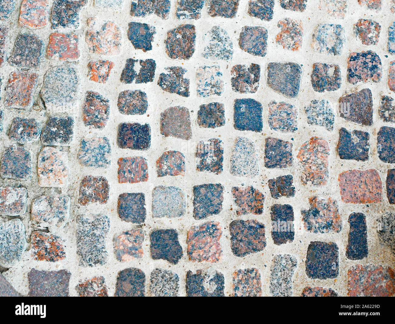 Alte Pflasterstein hautnah. Ein Teil der alten Mauer aus Stein für Hintergrund oder Textur. Grunge alten grauen Stein Wand Hintergrund mit Moos hautnah. Rauer Stein Stockfoto